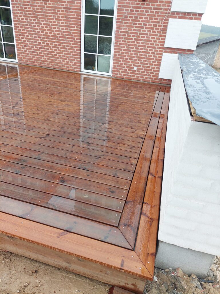 Nybygget træterrasse foran murstenshus