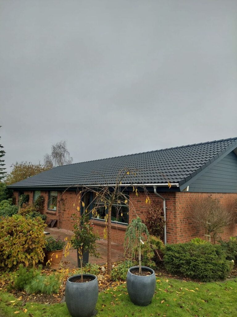Murstenshus med have og gråt tegltag