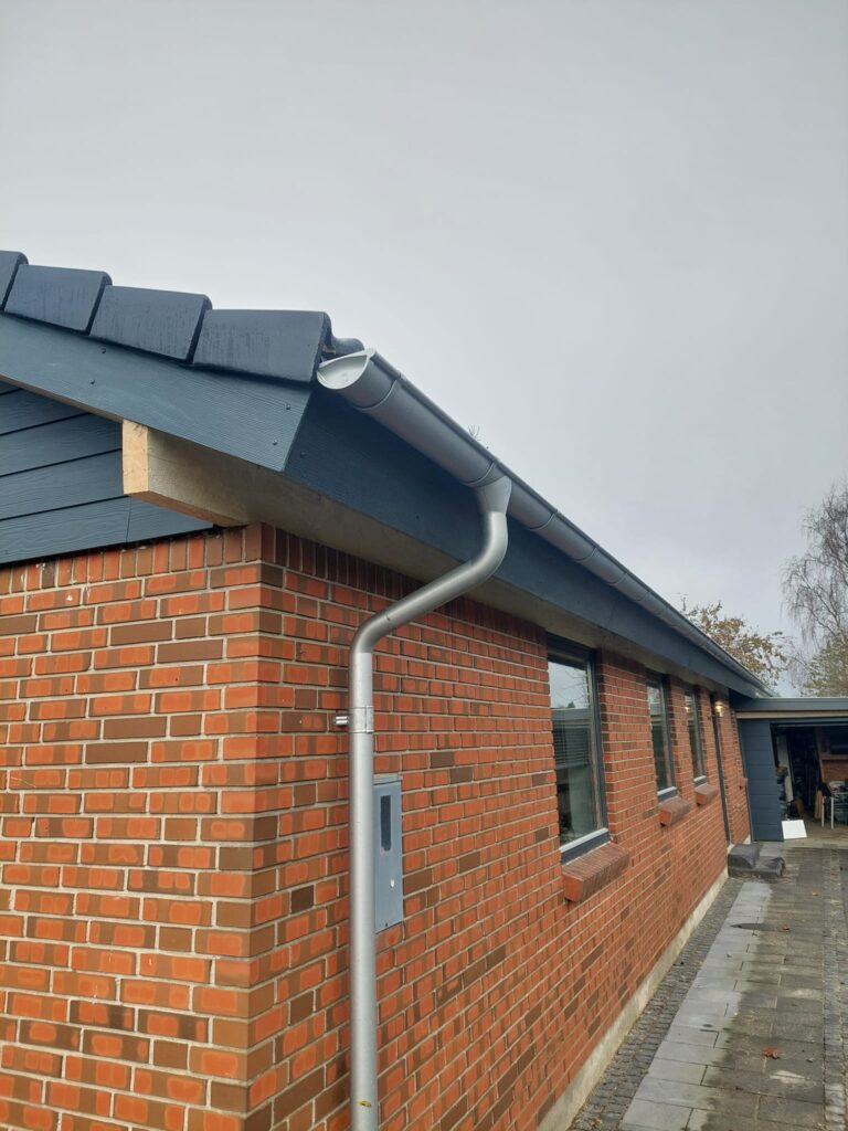 Murstenshus med ny tagrende og nedløbsrør